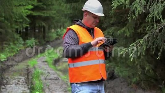 在车辙的森林道路上与平板电脑合作的森林官员视频