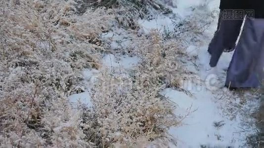 穿着宽大时髦裤子在雪地上行走的女孩视频