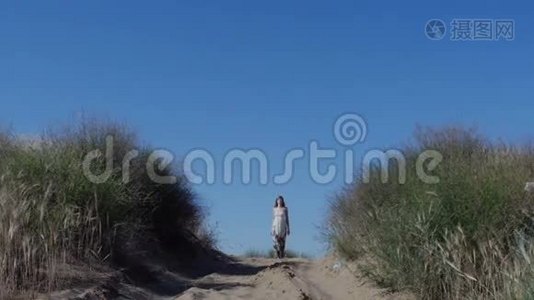 夏天穿裙子的女人走在沙滩上视频