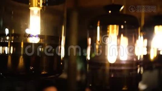 在一家环境优美的时髦咖啡馆里喝杯热咖啡时，从美丽的灯具中散发出温暖的灯光视频