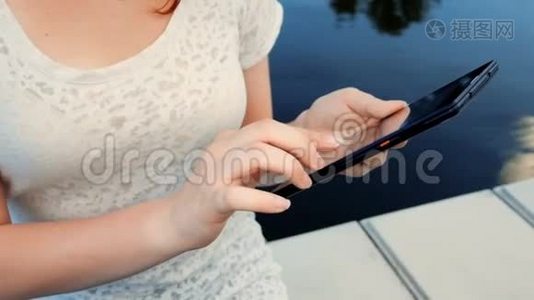 年轻女性使用触摸屏来放松平板电脑视频