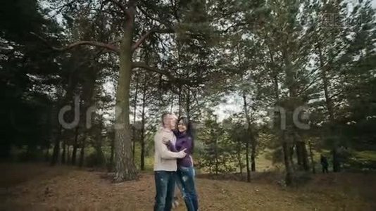 年轻的幸福夫妇在秋天的公园里一起度过快乐的时光。 晴天。 心情很好。 户外活动视频