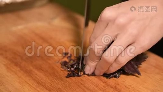 一个女孩的手特写在家厨房的一块木制砧板上小樱桃西红柿。家常菜视频