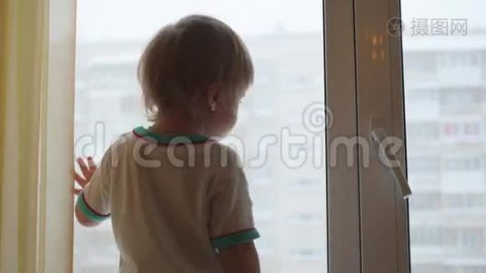 一个孩子站在窗台上，望着窗外视频