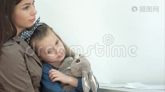 年轻的妈妈和她的小女儿带着小兔子去看医生视频