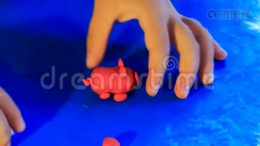 小孩的手在玩塑料蓝色玩具猪视频