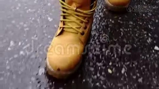 穿靴子的女人在潮湿的沥青中行走视频