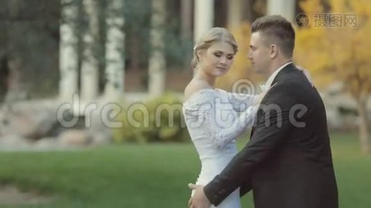 英俊的新郎举起新娘，她吻了他视频
