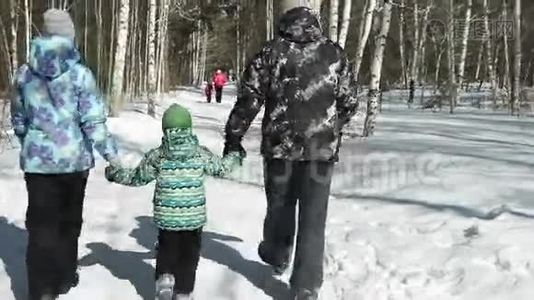父母牵着他们的儿子。 背面视频