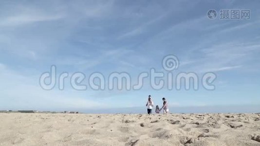 母亲和父亲带着孩子在海滩上奔跑视频