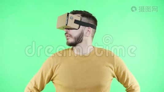 男人享受纸板谷歌VR耳机的电话视频