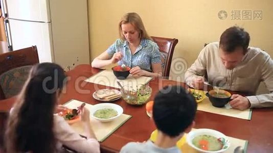 一家人在家里的餐厅用餐。 青少年、双胞胎及其父母视频