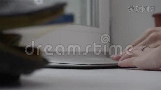 关闭工作手在笔记本电脑上的全景窗口。 在窗台上用笔记本电脑工作的女人视频
