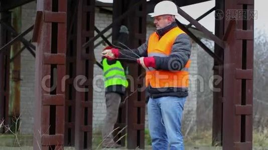 带钢丝和可调节扳手的工人在工厂工作视频