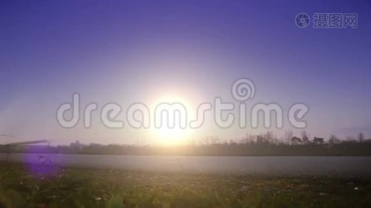 日落时两名骑自行车的人朝一个方向骑着的明亮的饱和镜头视频