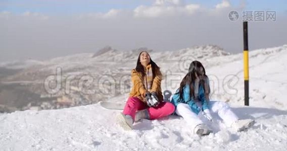两个年轻的女人在冬天的雪地里玩视频