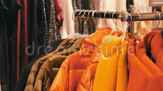时尚温暖的衣服挂在一家商场的服装店的衣架上。视频