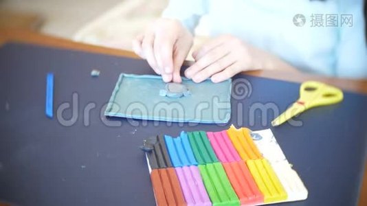 坐在桌子旁的女孩，从彩色模型塑料中画出不同的图形。 艺术造型的发展视频