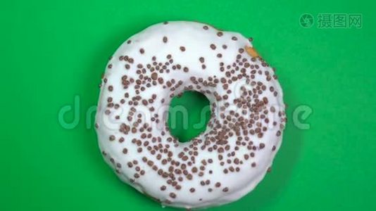 美味新鲜的甜甜圈特写镜头旋转在绿色背景上。视频