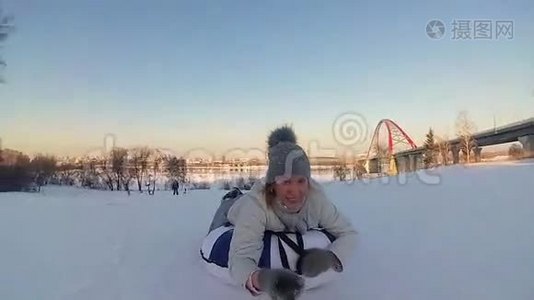 快乐的女孩骑着雪管在雪道上微笑。 慢动作。 冬天的雪景。 户外运动视频
