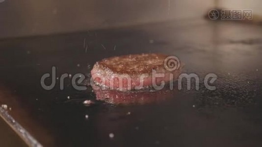 电动商业烤架上汉堡煎切片的4K慢动作镜头。视频