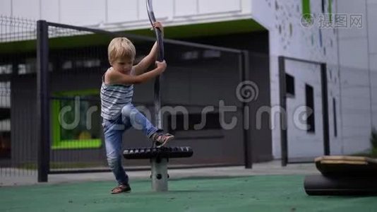 孩子们在现代城市的生活-小男孩在房子附近的操场上玩得很开心视频