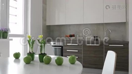 4K. 斯堪的纳维亚风格的现代厨房内部。 苹果和鲜花的运动全景视频