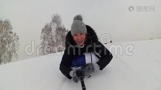 快乐的女孩骑着雪管在雪道上微笑。 慢动作。 冬天的雪景。 户外运动视频