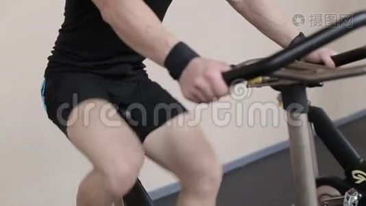 健身男在健身房骑运动自行车锻炼身体视频