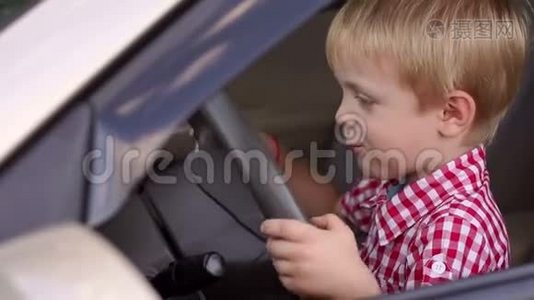 汽车车轮后面一个快乐男孩的肖像。视频