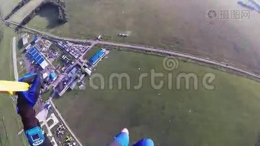 专业跳伞运动员在空中跳伞，在绿色的田野，道路上。 身高。视频