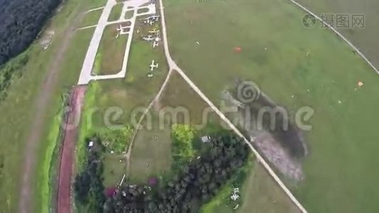 专业的跳伞运动员在空中降落，降落在绿野之上。 身高。视频