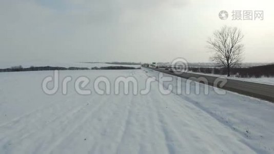在雪域驾驶冬季道路的卡车的空中射击。视频
