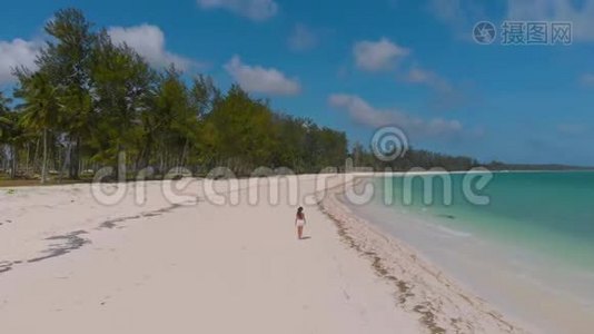 在布格苏克岛上的彭塔塞巴林，一个被绿松石水环绕的白色沙滩上，女子漫步的空中镜头视频