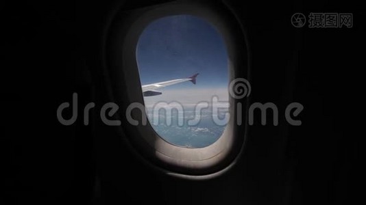 透过飞机的窗户观看蓝天和云彩，用飞机的翅膀关闭飞机的窗户视频
