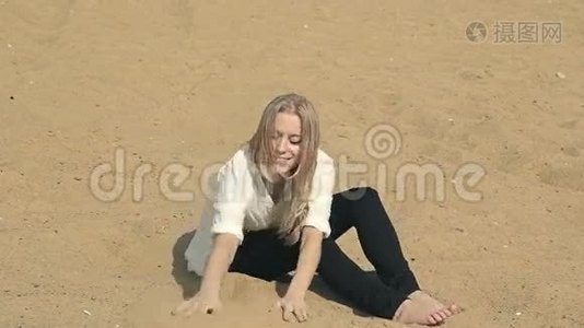 美丽的女孩坐在沙滩上看着视频