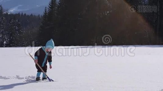 小女孩用雪铲撒雪的慢动作视频