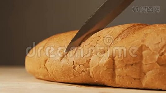 在木制桌面上用菜刀切制的新鲜烘焙面包。视频