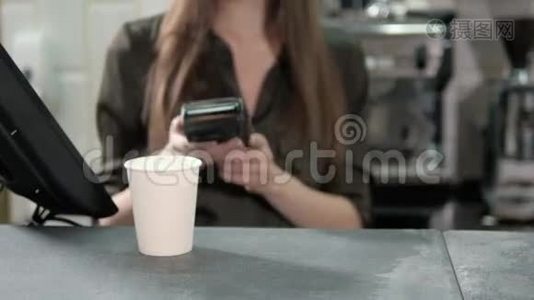 为智能手机买单。 现代咖啡馆里，一个英俊的男人用他的手机向服务员支付交易视频