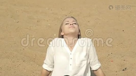 美丽的女孩坐在沙滩上微笑着视频