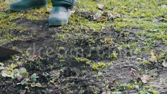一个女人在花园里工作，用一把锄头把地上的草擦干净视频