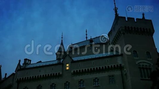 中世纪的城堡场景：随着黄昏的降临，窗户里逐渐出现了灯光。 一群鸟从屋顶上飞过。视频