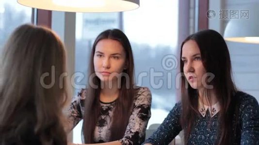 双胞胎仔细地听着她的女朋友，在咖啡馆里震惊视频