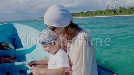 母亲和儿子在海上旅行时使用垫子视频