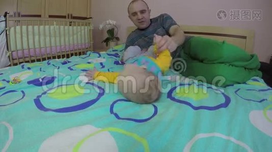父亲帮助他的宝贝女儿在家里翻床。 4K视频