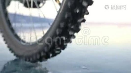 轮胎的视图。 拍摄180fps.. 女人在冰上骑自行车。 冰的贝加尔湖。 上面的轮胎视频