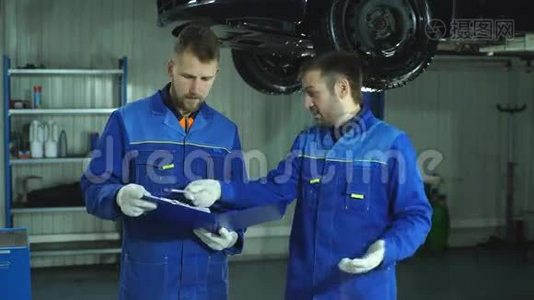 两名身穿蓝色制服的汽车修理工为汽车的全面诊断做准备视频
