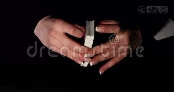女人用手在黑色背景下挥舞扑克牌视频