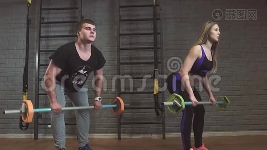 在健身房锻炼杠铃肌肉的男人和女人视频