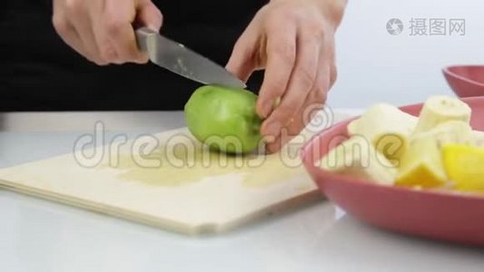女人在厨房的木板上切奇异果。视频